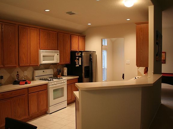Beautiful large kitchen with Corian countertops and ceramic tile backsplash