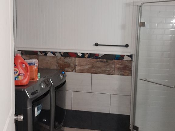 Has a shower with front end load washer and dryer that's about a year old.