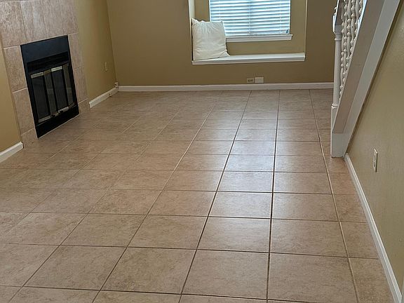 Den with window seat and fireplace. Ceramic tile floors