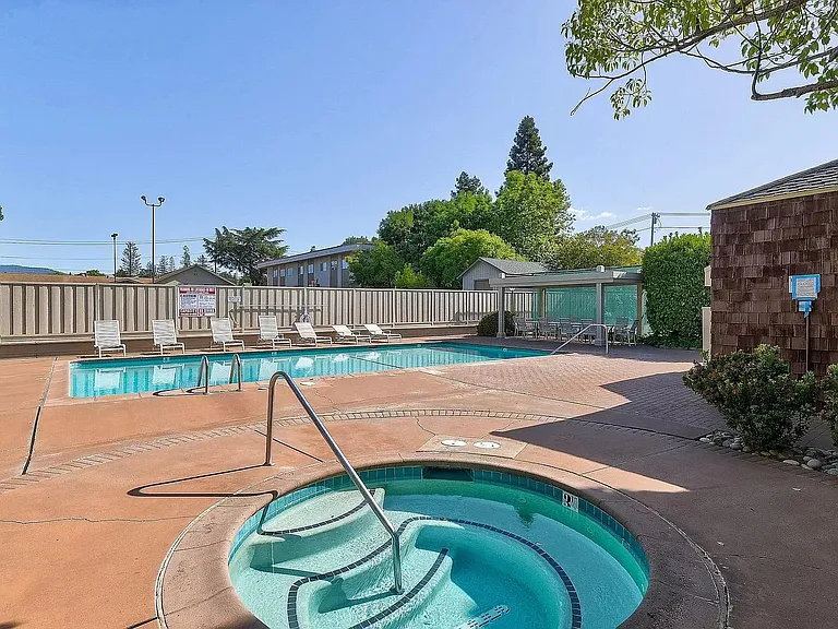 Swimming Pool with hot tub Jacuzzi. Eating area under shade and plenty of lounge chairs.