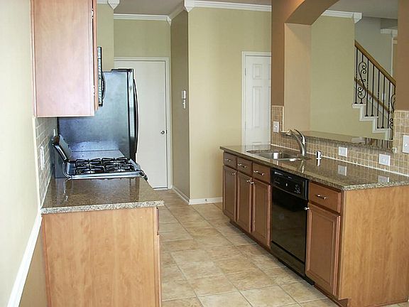 Open galley kitchen with granite countertops