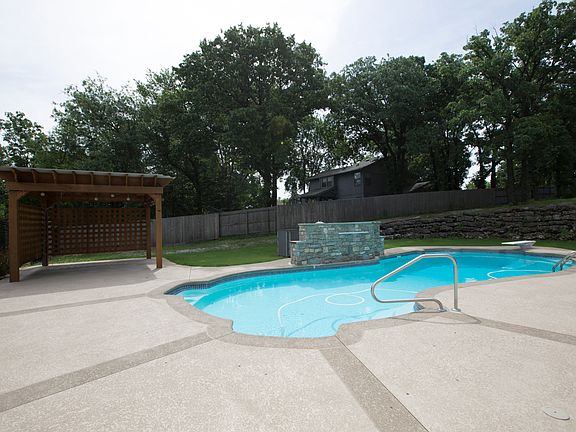 Fabulous Outdoor Living featuring sparkling Dive Pool with Waterfall, extended cool deck and custom Pergola.