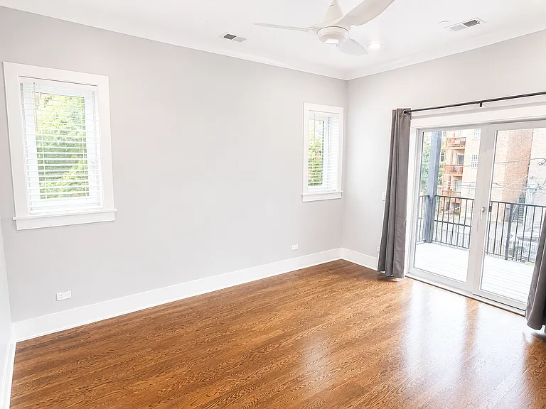Primary Bedroom with access to rear balcony, media ready wall for television and additional two windows.