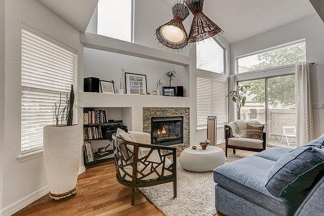 Living room with vaulted ceiling, lots of light and gas fireplace.