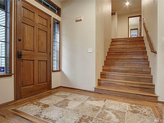 Extra-wide staircase like a custom home!  Gorgeous front door surrounded by light!  And ceramic tile floor inlay so wood floors stay pristine!
