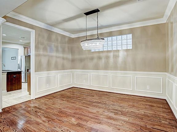 Beautiful hardwood floors and stunning chandelier frame the dining room