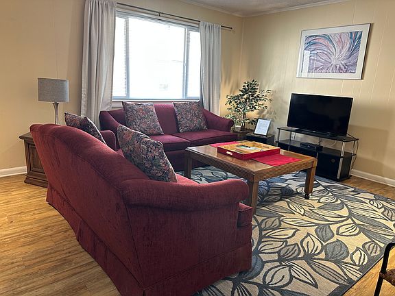 Inviting living room with two comfortable couches, a TV, dining area, and plenty of storage - welcoming you as soon as you step into the unit.