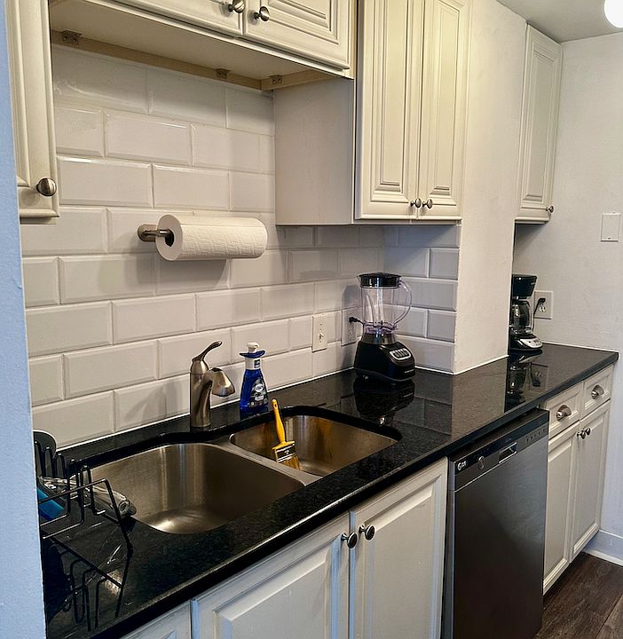 Classy set up with white subway tile and sleek easy to keep looking nice black granite.