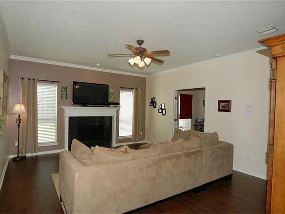  The living room features handsome hardwood engineered flooring, a tile surround (gas) fireplace and crown molding. The accent wall color highlights the fireplace and two windows on each side!