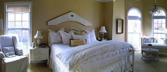 Spacious master bedroom located on main floor with sitting area and windows on two sides.