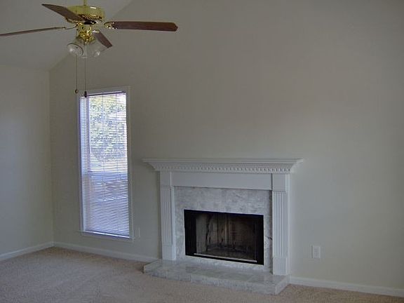 Great room with cathedral ceiling, marble mantel/wood-burning fireplace.