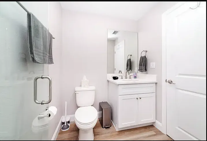 Full ensuite bath with single vanity, tiled shower, and toilet.