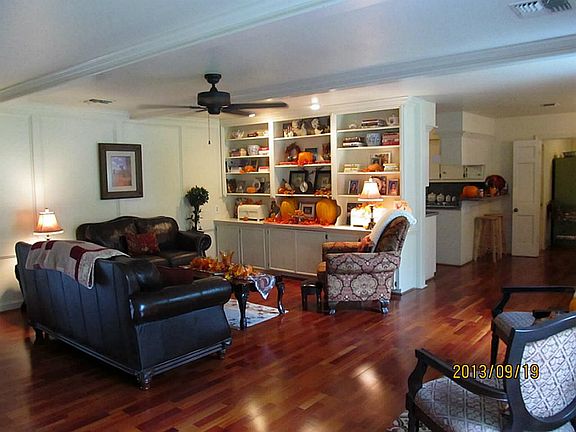 Great living area features wood floors, ceiling fan and floor to ceiling built in cabinets for enter