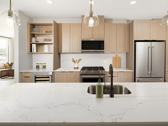 Signature Collection Kitchen with oak shaker cabinetry, marbled white quartz countertop and backsplash, and upgraded stainless steel appliances