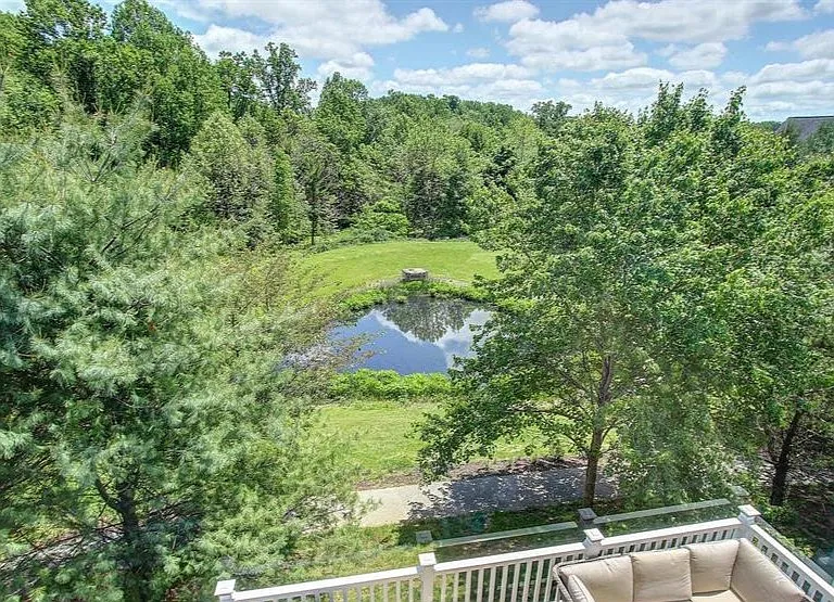 Rear view showcasing the deck and wooded backdrop