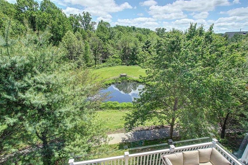 Rear view showcasing the deck and wooded backdrop