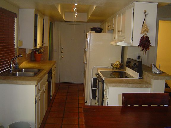 Kitchen updated with tile counters, tumbled stone backsplash,and new sink .