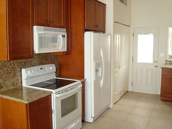 Kitchen appliances: Electric stove top and oven; Microwave oven; Double Door Refrigerator with water/ice dispenser; Washer/Dryer behind sliding doors left of back door out to rear patio and access to Ocean view deck.