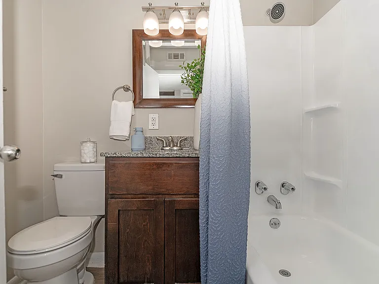 Bright bathroom with granite counters and bathtub