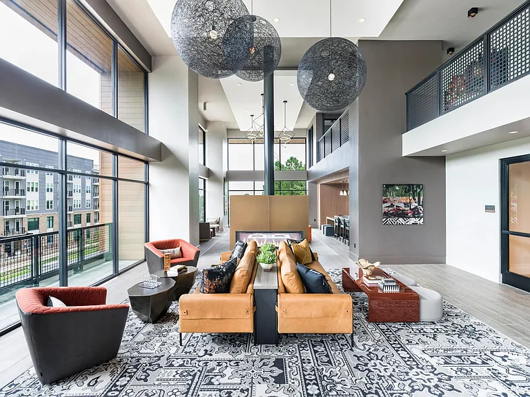 Expansive lounge with floor-to-ceiling windows, designer seating, and a fireplace centerpiece_an inviting retreat at Modera LoSo.