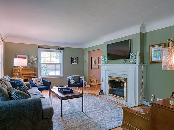 Spacious living room with wood burning fireplace. Cove ceiling and beautiful wood floors. TV and piano stay.