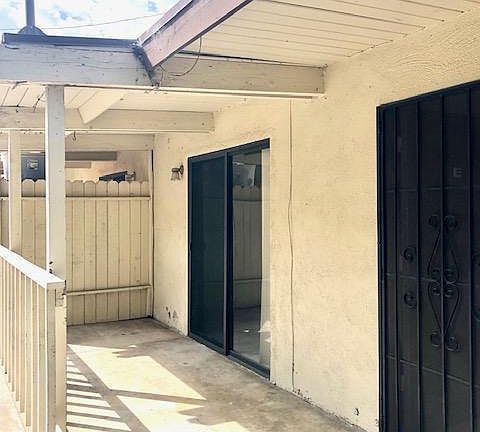 Covered front porch with sliding door leading to bedroom two.