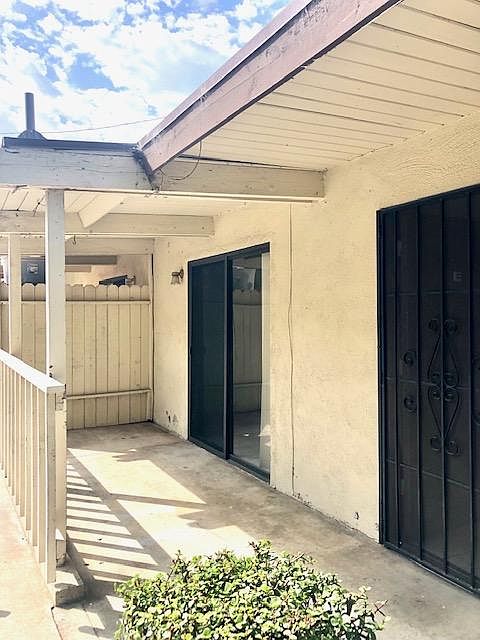 Covered front porch with sliding door leading to bedroom two.