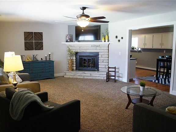 Huge upstairs living room with a gas fireplace and large windows to bring in natural light.
