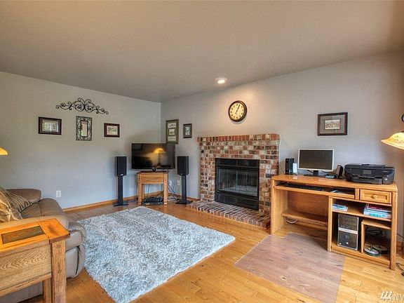 Living room features a wood burning fireplace and beautiful hardwood flooring 