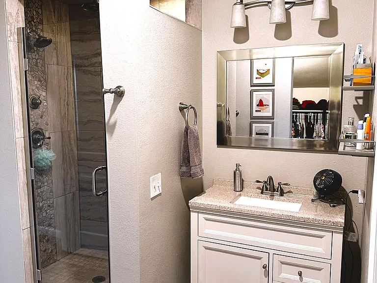 Master bathroom with large dual head tiled shower and large walk-in closet.