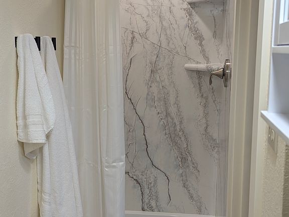 Roomy walk in shower in bathroom.