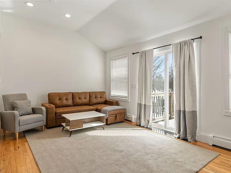 Living Area, Hardwood Floors, Natural Light, Sliding Glass Door, Neutral Decor, Open Concept, Vaulted Ceiling.