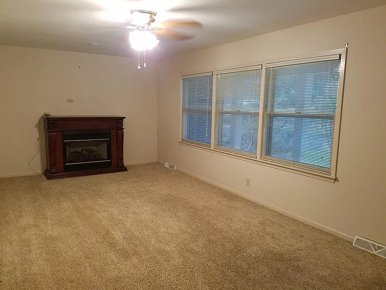 Large living room with ceiling fan and large windows for gre