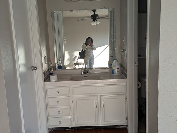 cabinet with tiled backsplash and mirror in masterbedroom