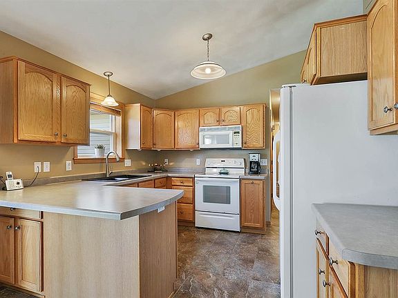 Sparkling kitchen with eat in snack bar and pantry.