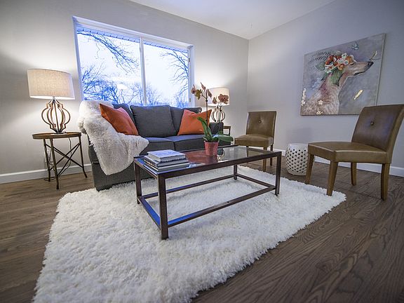 Open concept living room (18x16) features the newly refinished oak hardwood flooring, new paint and trim throughout and a large window view of the front yard.