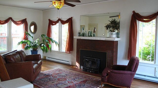 Living room, hardwood floor, lots of newer vinyl windows for natural lighting 