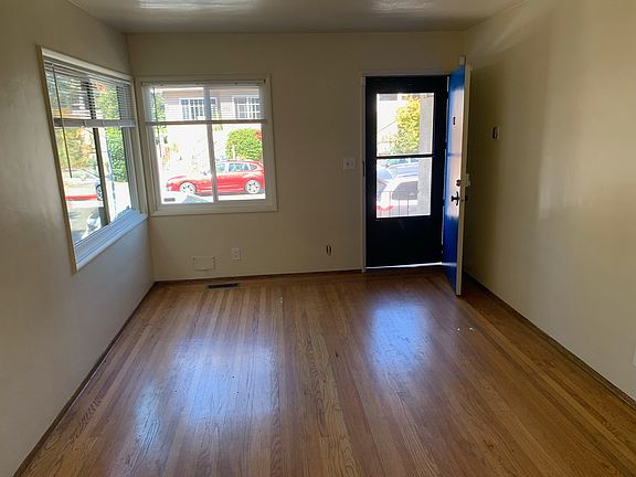 Natural light floods the living room from vinyl picture windows, NEW cordless blinds, and a fresh coat of paint