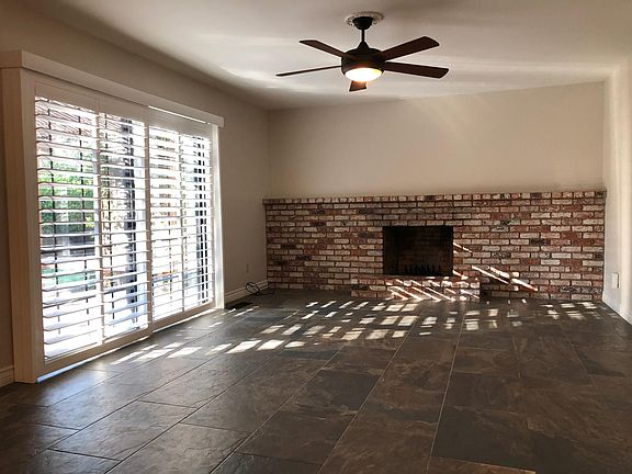 Family room with brick fireplace and sliding doors out to patio deck