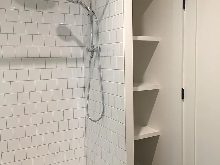 Bathroom. Rain shower with handheld shower and shelving.