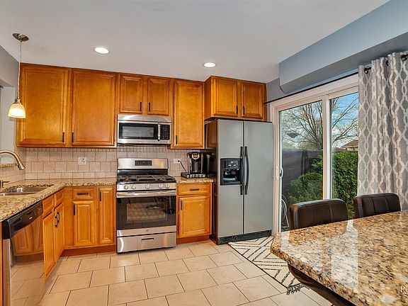 Wood Cabinets with Granite Counters with view to the Living Room and Patio Backyard!