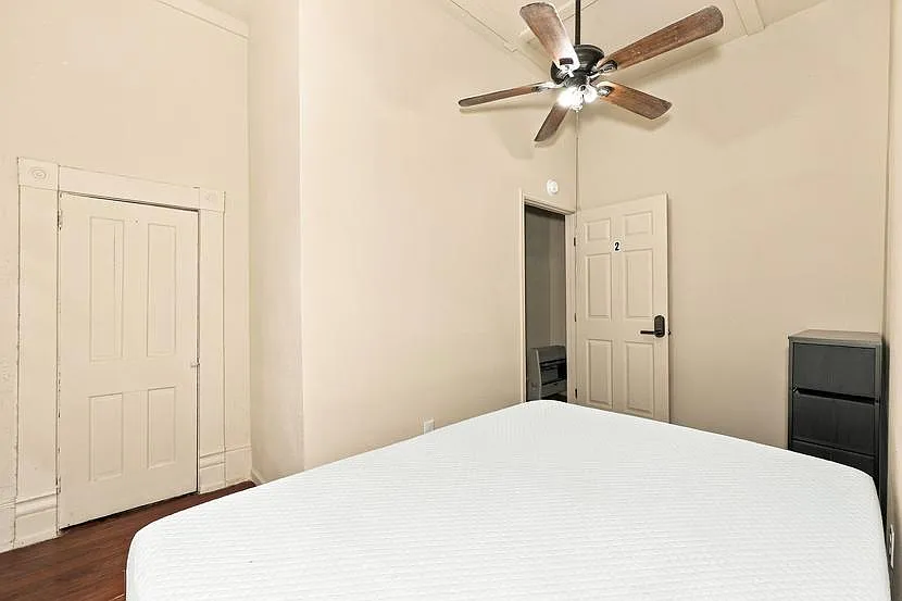 Private bedroom with tall ceilings, a ceiling fan, and space for a full bed plus storage; convenient access to closet and hal