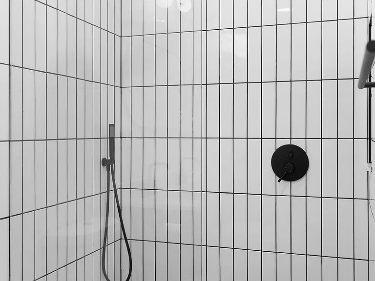 Walk-in rain shower with floor-to-ceiling tile and glass enclosure