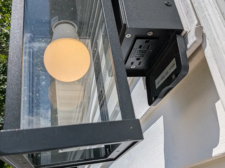 Side entrance exterior light includes gfci electrical outlets.