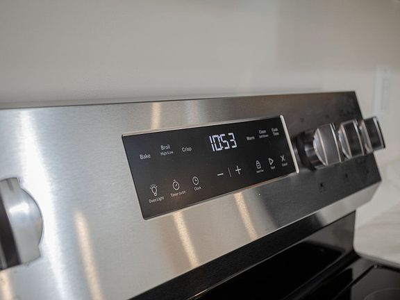 The electric range has four cooking burners and a warming spot on the glasstop surface. There is a storage drawer under the oven.
