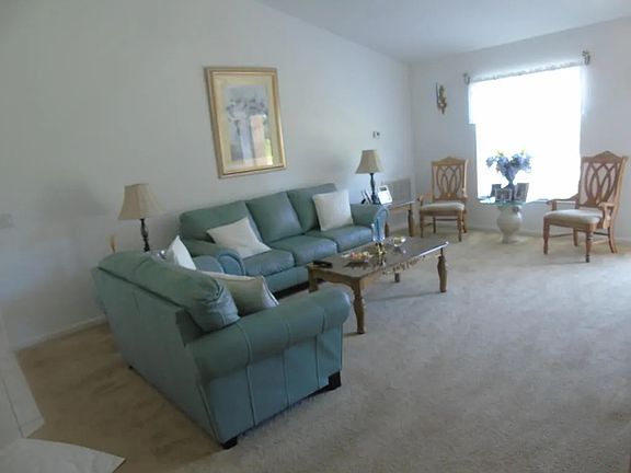 Vaulted ceiling Living room with new ceiling fan and floor in gray.