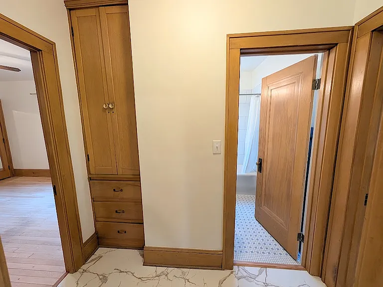 [LOWER UNIT]: living space hall with linen closet, bathroom and rooms on the left and right