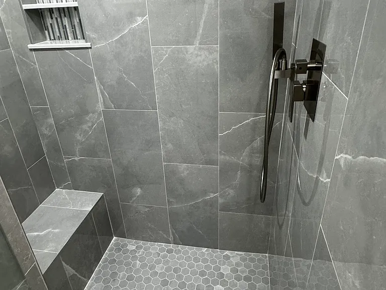 New shower with built in bench seat and a wonderful rain shower head and a separate hand held shower head . Glass door was custom made and is frameless .