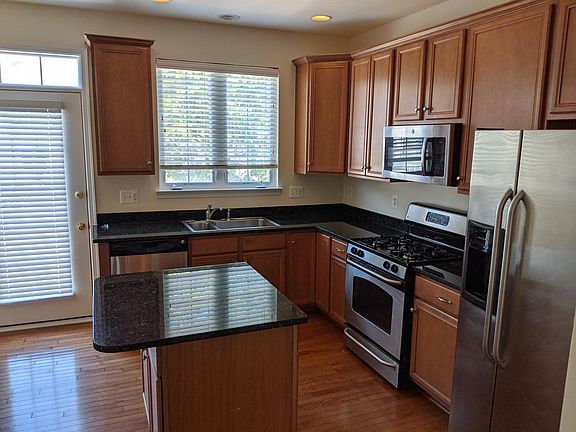 Kitchen with granite counters and pull-out shelves in cabinets including pantry