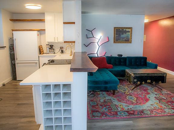 Spacious living room featuring an L-shaped couch facing built-in bookshelves and a cozy fireplace, creating a warm and inviting atmosphere.